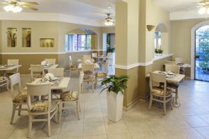 a dining room with tables and chairs in a restaurant at Hotel & Suites Quinta Magna in Guadalajara