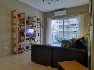 a living room with a couch and a window at Hermoso departamento 3 amb. en el centro de Olivos in Olivos