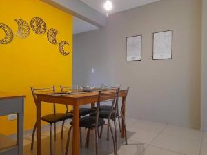 a dining room table with chairs and a yellow wall at Hermoso departamento 3 amb. en el centro de Olivos in Olivos