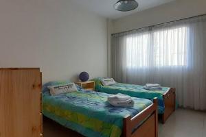 two twin beds in a room with a window at Hermoso departamento 3 amb. en el centro de Olivos in Olivos