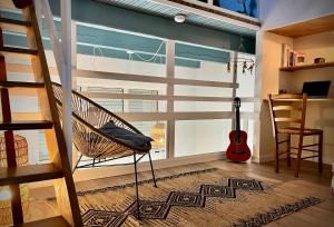 Cette chambre dispose d'un hamac et d'une fenêtre avec une guitare. dans l'établissement Maison de village avec jardin à 3 km des plages., à Loupian