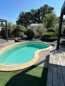 een klein zwembad in een tuin met een houten terras bij Studio « L’instant présent » balnéothérapie in Gaillac