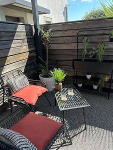 een patio met 2 stoelen en een tafel met planten bij Studio « L’instant présent » balnéothérapie in Gaillac