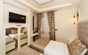 Habitación de hotel con 2 camas y TV de pantalla plana. en Zeynep Sultan Hotel en Estambul