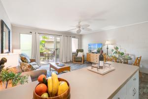 uma cozinha e sala de estar com uma tigela de frutas no balcão em Maui Sands Seaside 713 em Kahana