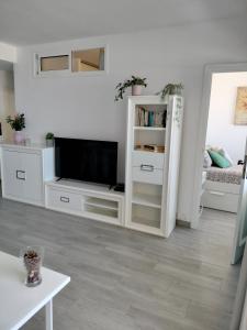 a white living room with a tv and a couch at Relax And Sunset in Paraiso Adeje in Adeje
