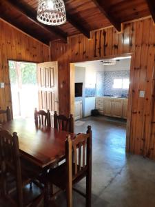 a dining room with a wooden table and chairs at Cabaña Buena Madera in San Vicente