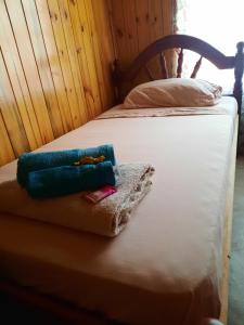 a bed with two towels on top of it at Cabaña Buena Madera in San Vicente