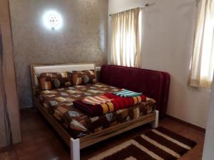 une chambre avec un lit avec une couverture dessus dans l'établissement Habib Villa Tulips, à Ooty