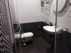 une salle de bain avec des toilettes blanches et un lavabo dans l'établissement Habib Villa Tulips, à Ooty 12 autres photos