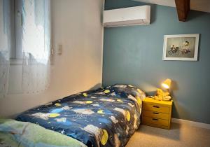 - une chambre avec un lit et une commode avec une lampe dans l'établissement Maison de village avec jardin à 3 km des plages., à Loupian