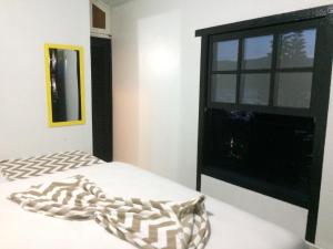 1 dormitorio con cama y ventana en Solar dos Anjos, en Arraial do Cabo
