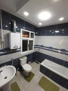 La salle de bains est pourvue de toilettes, d'un lavabo et d'une baignoire. dans l'établissement Smart hom, au Caire
