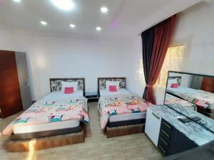 - une chambre avec 2 lits et un bureau dans l'établissement Smart hom, au Caire