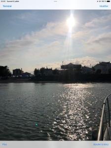 um barco na água com o sol no céu em Le petit beauregard em Le Fenouiller