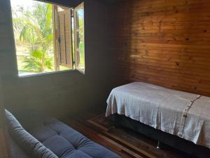 uma sala de estar com um sofá e uma janela em Chácara Belvedere.Espaço rural, descanso e lazer em Londrina