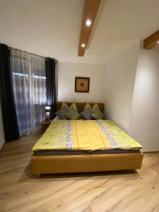 1 dormitorio con 1 cama con edredón amarillo en Apartment Serlesblick, en Ellbögen