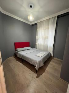een slaapkamer met een rood bed en een raam bij Luxuryyy in Istanbul