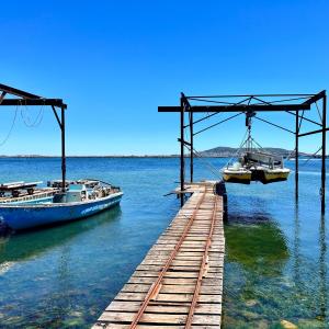 deux bateaux sont amarrés à un quai dans l'eau dans l'établissement Maison de village avec jardin à 3 km des plages., à Loupian