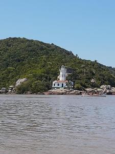 a lighthouse on the shore of a body of water at Cabana recantodosamigositapua praia dos passarinhos itapua in Viamão