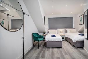 een kleine kamer met 2 bedden en een spiegel bij Spacious, High Spec & Modern House by Ark SA in Sheffield