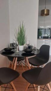 una mesa de comedor con copas de vino y sillas en Luxury Apartment, en Tyczyn