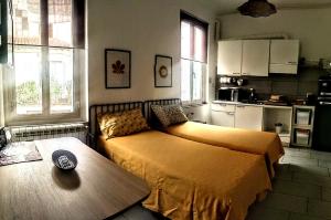 a bedroom with a bed and a table and a kitchen at Appartamento Porta Est in Foligno
