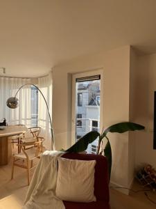 sala de estar con sofá, mesa y ventana en Delvaux Oostende, en Ostende