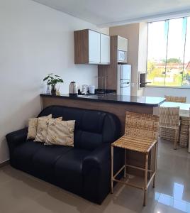 a living room with a couch and a kitchen at Apto completo praia Caioba in Matinhos