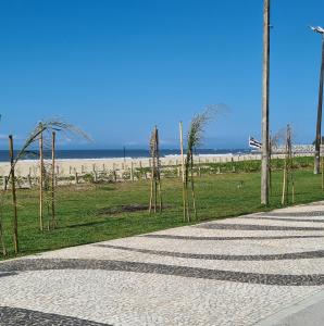 a walkway next to a beach with palm trees at Apto completo praia Caioba in Matinhos