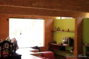 Sítio em Itapecerica da serra في إتابيسيريكا دا سيرا: غرفة معيشة مع نافذة كبيرة وتلفزيون