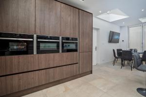 a living room with a large wooden entertainment center at Spacious, High Spec & Modern House by Ark SA in Sheffield