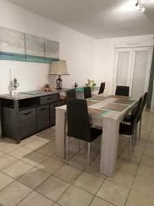 - une cuisine avec une table à manger et des chaises dans l'établissement Maison sur les hauteurs de Carcassonne, à Carcassonne