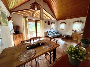 ein Wohnzimmer mit einem Holztisch und Stühlen in der Unterkunft Cosy cottage in countryside in Šentjernej