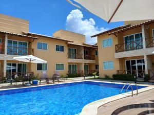 a swimming pool in front of a building at LAZER EM GUARAJUBA in Guarajuba