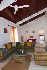 a living room with couches and a ceiling fan at Villa Sunrise in Deshaies