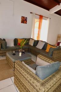Sala de estar con 2 sofás y mesa en Villa Sunrise, en Deshaies