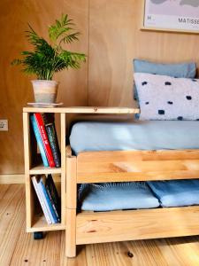 a wooden bunk bed with a book shelf and a potted plant at cabaña CasaOtto in Los Caños de Meca