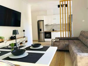 a living room with a couch and a table with bowls on it at 2 Bedroom Family Apartment with Free Parking in Thessaloniki