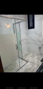 a shower with a glass door in a bathroom at Sweet home three bedroom house in Sousse