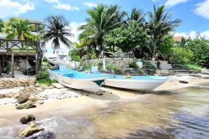 two boats sitting on the shore of a beach at Villa on The Beach Seaside Sunrise Haven 7 bedroom in Cancún