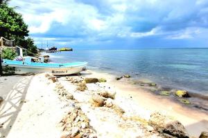 a boat sitting on the shore of a beach at Villa on The Beach Seaside Sunrise Haven 7 bedroom in Cancún