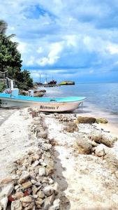 a boat sitting on a beach next to the water at Villa on The Beach Seaside Sunrise Haven 7 bedroom in Cancún