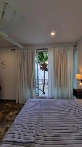 a bedroom with a large bed and a palm tree at Villa on The Beach Seaside Sunrise Haven 7 bedroom in Cancún