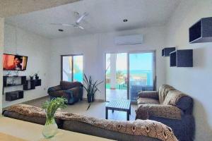 a living room with two couches and a table at Villa on The Beach Seaside Sunrise Haven 7 bedroom in Cancún