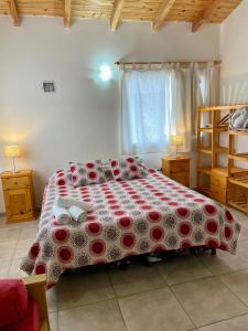 una camera con un letto e un piumone rosso e bianco di Alboraya apartamentos a Dina Huapi