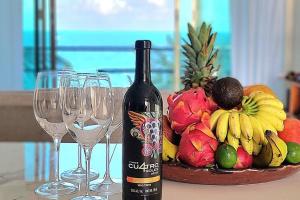 a bottle of wine next to a bowl of fruit and wine glasses at Villa on The Beach Seaside Sunrise Haven 7 bedroom in Cancún