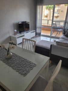 a living room with a table and a couch and a television at CasaBel - Playa in Torrox Costa