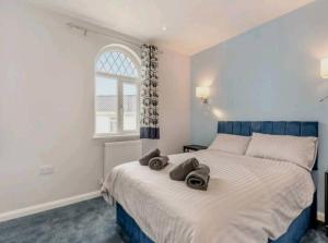 Sea View Luxury 5 Star Cottage Near Milford Marina في بيمبروكشاير: غرفة نوم بسرير كبير عليها منشفتين
