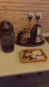 a counter top with a coffee maker and a tea kettle at كوخ الغصن الريفي in Jeddah